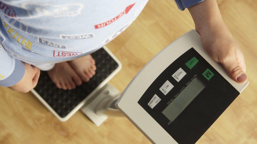 A little boy on a weighing scale