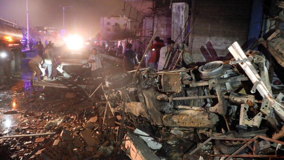 Yemenis inspect the scene of a car bomb attack outside Aden airport in the southern port city of Aden, Yemen, 30 October 2021