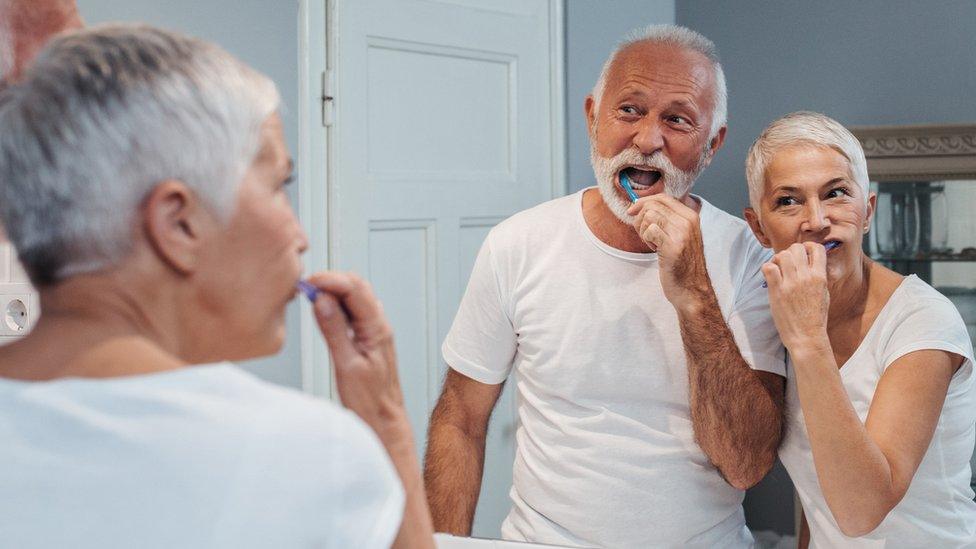 Older people brushing their teeth