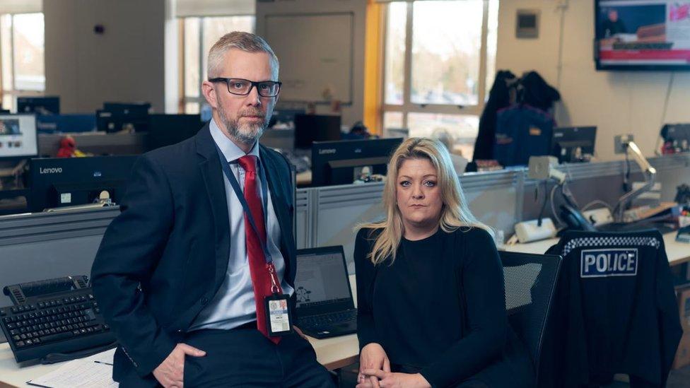 Picture of two people sat at desks in police office