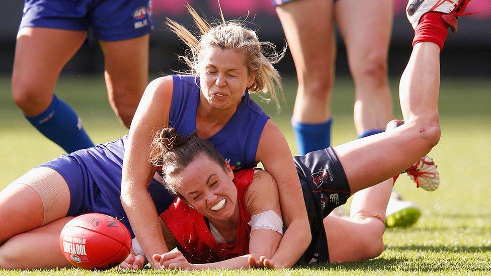 Katie Brennan tackles an opposition player, Daisy Pearce, in a legal move during a match in 2015