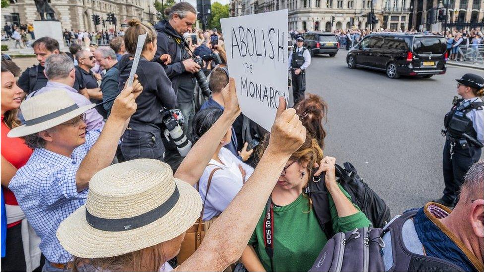 A protester with a placard saying Abolish the Monarchy as King Charles III leaves Parliament