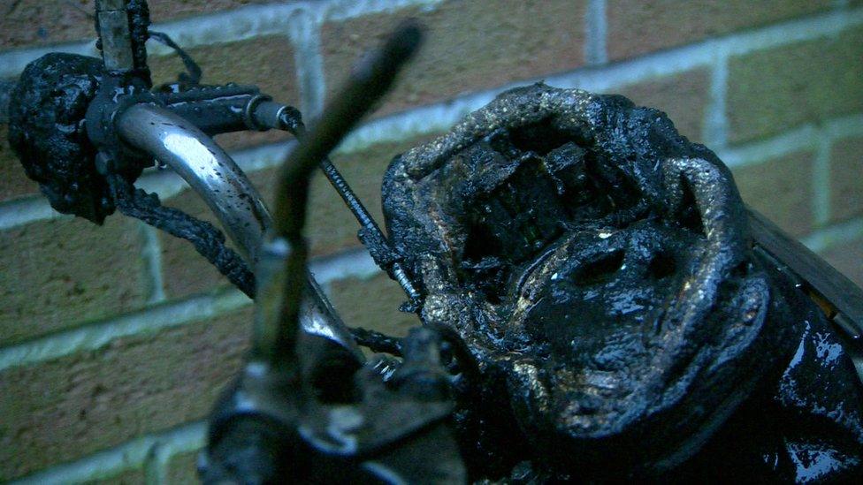 A charred motorbike that was set on fire outside the flats