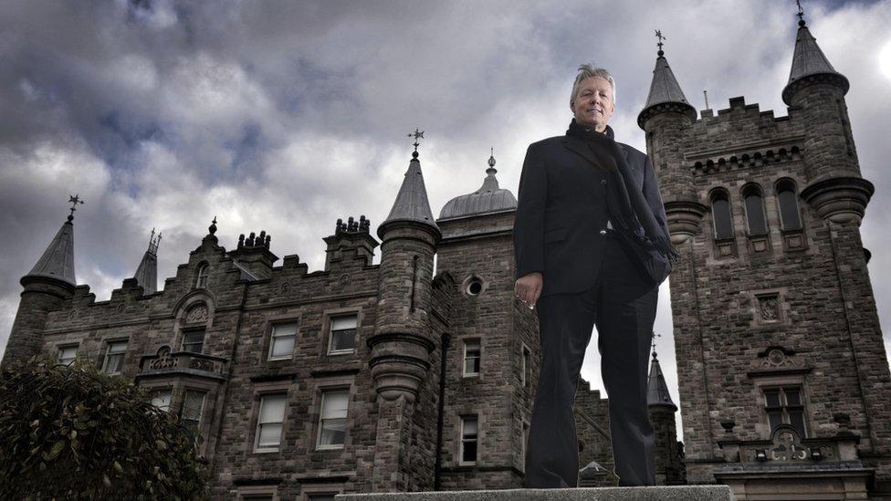 Peter Robinson standing in front of Stormont Castle