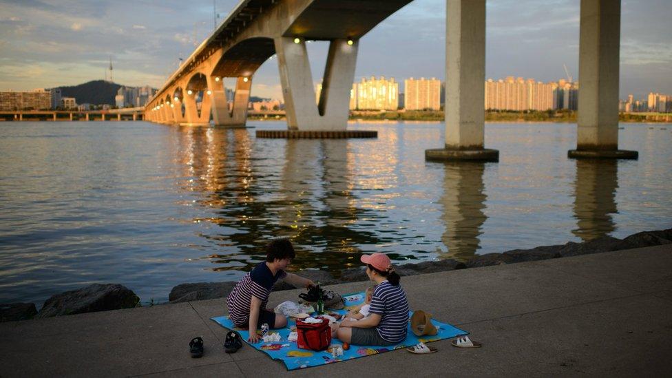 A family picnics by the banks of the Han River in Seoul