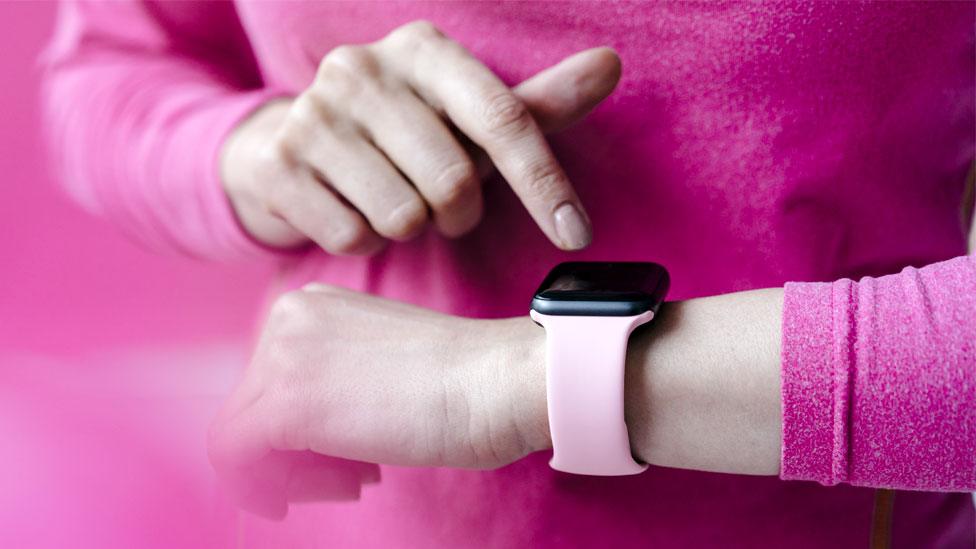 A woman uses a smartwatch