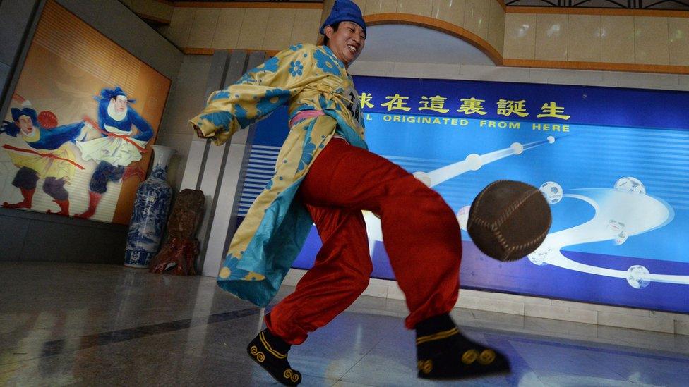 Man in traditional cuju clothes playing with a ball at the Linzi Football Museum in Zibo, Shandong Province