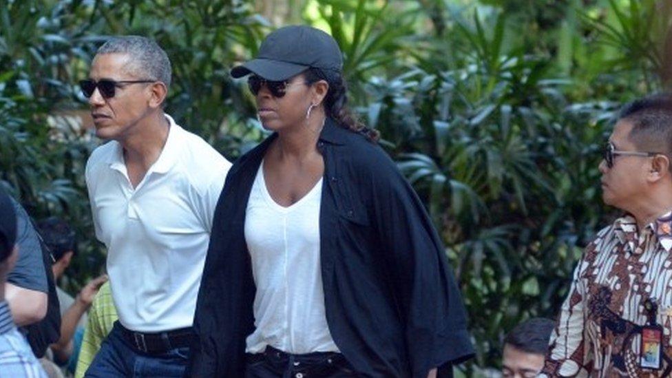 Former US President Barack Obama and his wife Michelle walk during a visit to Tirta Empul Temple in Gianyar, Bali (27 June 2017)