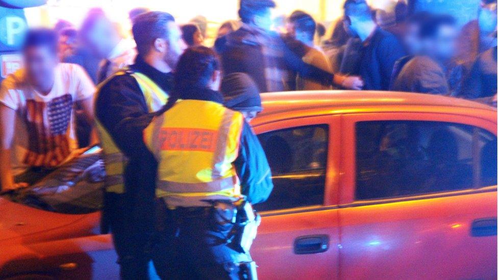 A man is led away by police officers at the main train station in Cologne, Germany (early hours of 01 January 2016)