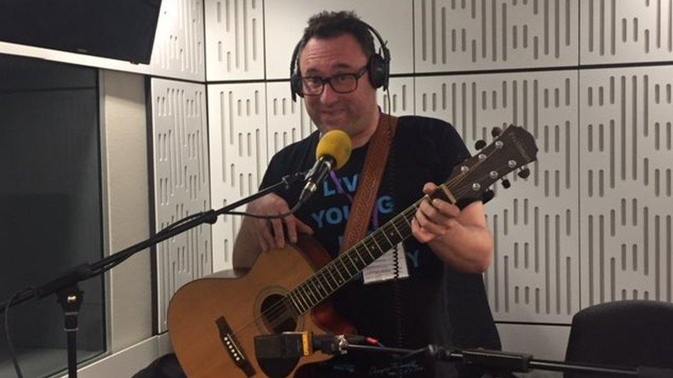 Chris Smith performing his song with a guitar