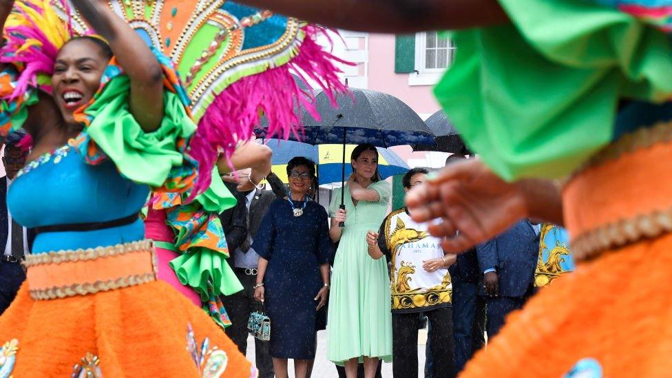 The duke and duchess sheltered under umbrellas