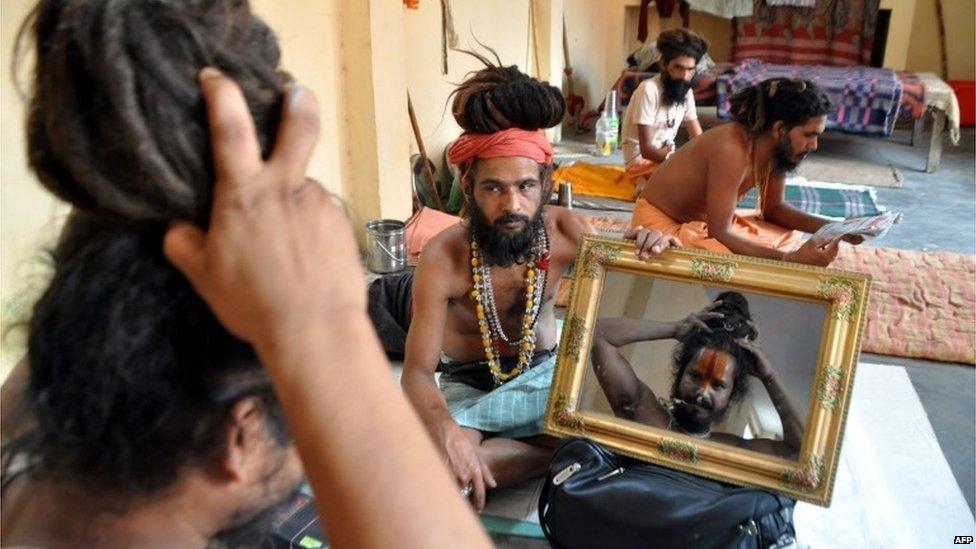 Indian sadhu -holy man-, Vishnu Dass (L) from Ayodhya in Uttar Pradesh state gets ready to do daily chores at a local temple in Jammu on June 20, 2015, as he and others await registration for the upcoming pilgrimage to Amarnath in Kashmir. The two month-long annual pilgrimage to the holy cave Shrine of Amarnath in Kashmir is scheduled to begin on July 2.