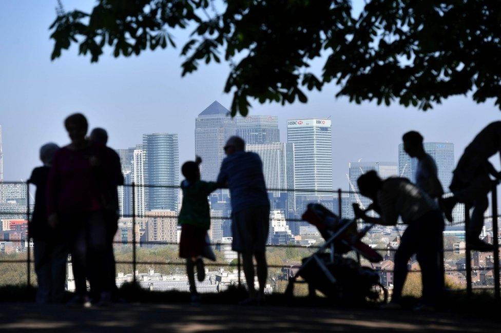 People look at Canary Wharf in London