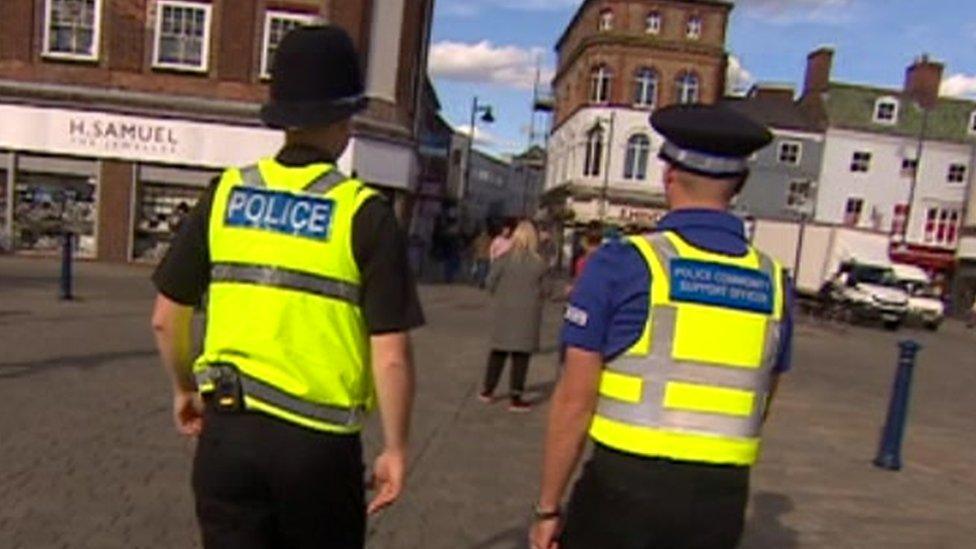 Police officer walking alongside a PCSO