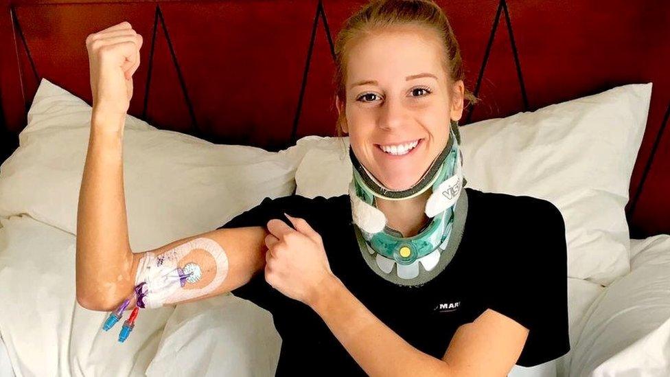 Victoria Graham in a hospital bed, showing her IV line and in a head brace.