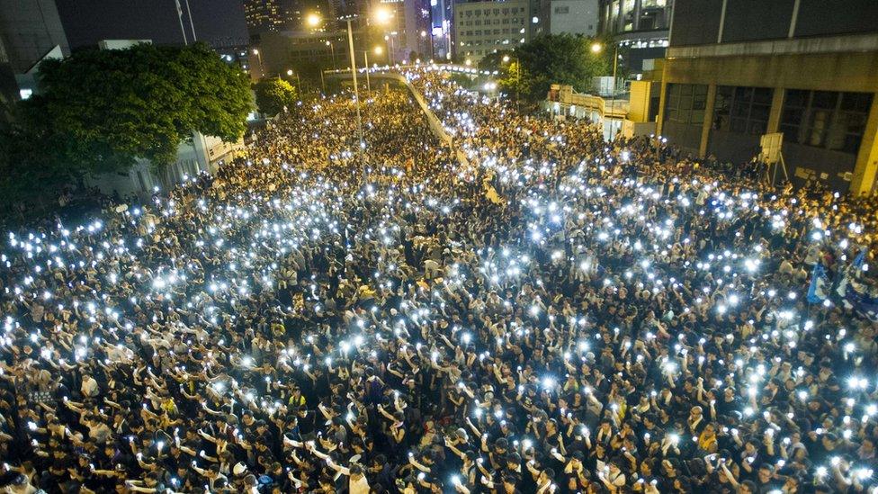 Protestors and student demonstrators hold up their cellphones in a display of solidarity during a protest outside the headquarters of Legislative Council in Hong Kong on September 29, 2014