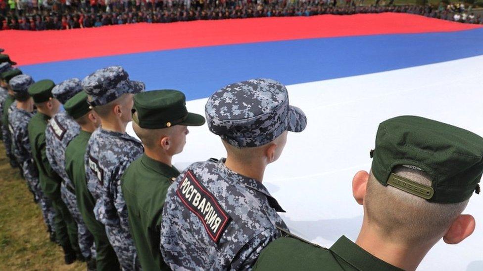 Russian soldiers hold a huge Russian flag to mark Russian National Flag Day in Moscow, Russia, on 22 August 2022