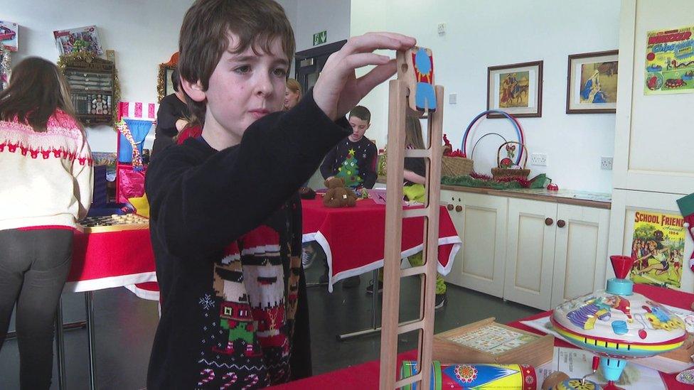 A boy plays with a wooden toy