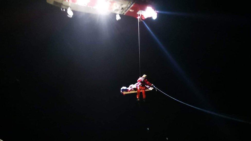 Injured man being assisted on to a stretcher