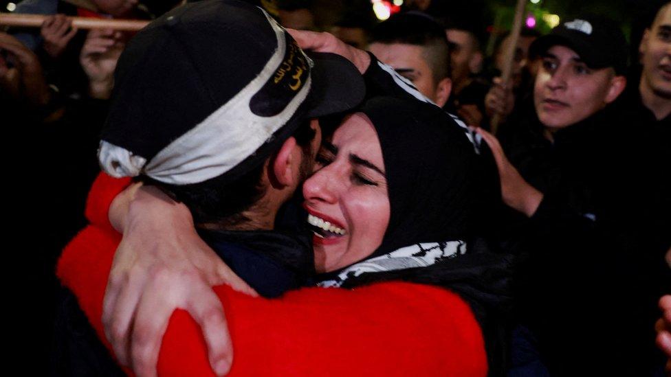 A Palestinian mother cries as she hugs her returned son