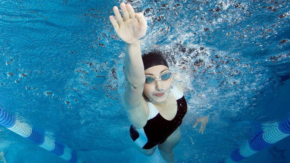 Stock image of people swimming in a swimming pool