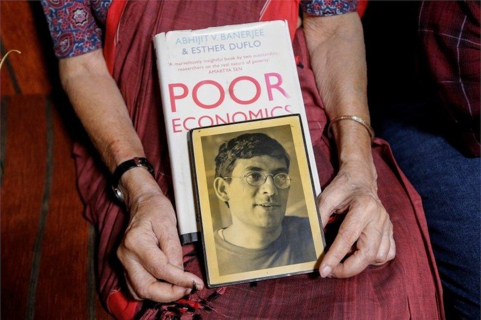 Nirmala Banerjee, mother of Abhijit Banerjee, one of the winners of 2019 Nobel Economics Prize, holds his portrait and one of his books, as she speaks to media at her house in Kolkata, India, October 14, 2019.