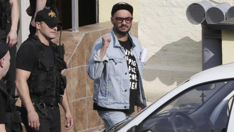 Russian theatre director Kirill Serebrennikov (3rd R), who was accused of embezzling state funds, is escorted outside a court building after a hearing on his detention in Moscow