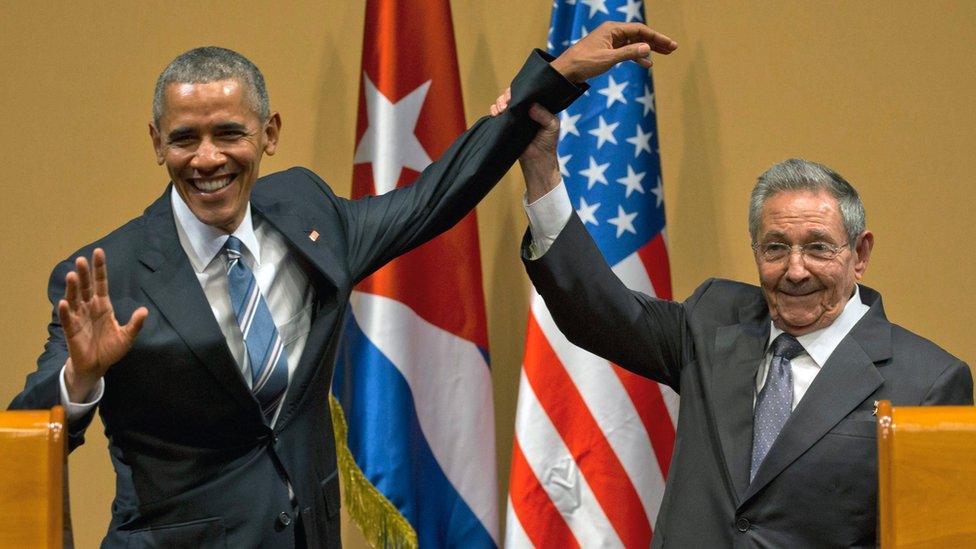 In this March 21, 2016 file photo, Cuban President Raul Castro, right, lifts up the arm of President Barack Obama at the conclusion of their joint news conference at the Palace of the Revolution, in Havana, Cuba