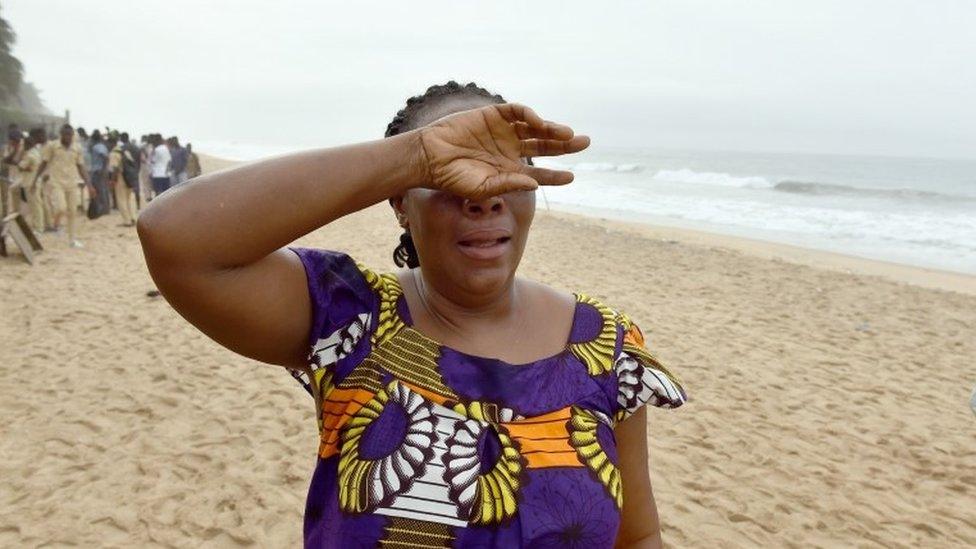 A woman looks for her son along the beach in Grand Bassam, Ivory Coast