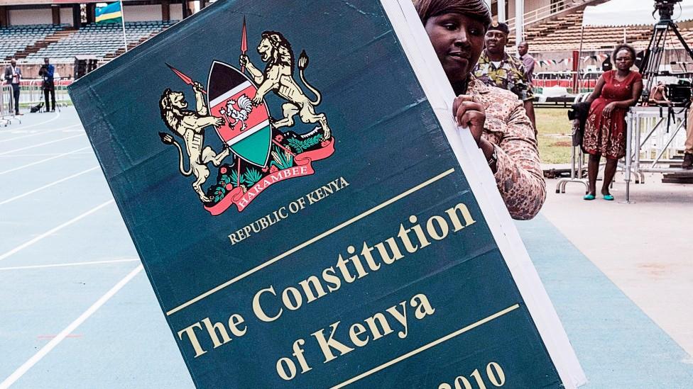 A woman carries a giant replica of the constitution of Kenya ahead of a presidential inauguration ceremony in Nairobi - 17 November 2017