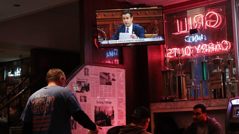 People in a bar in Chicago with the impeachment hearing on a TV screen