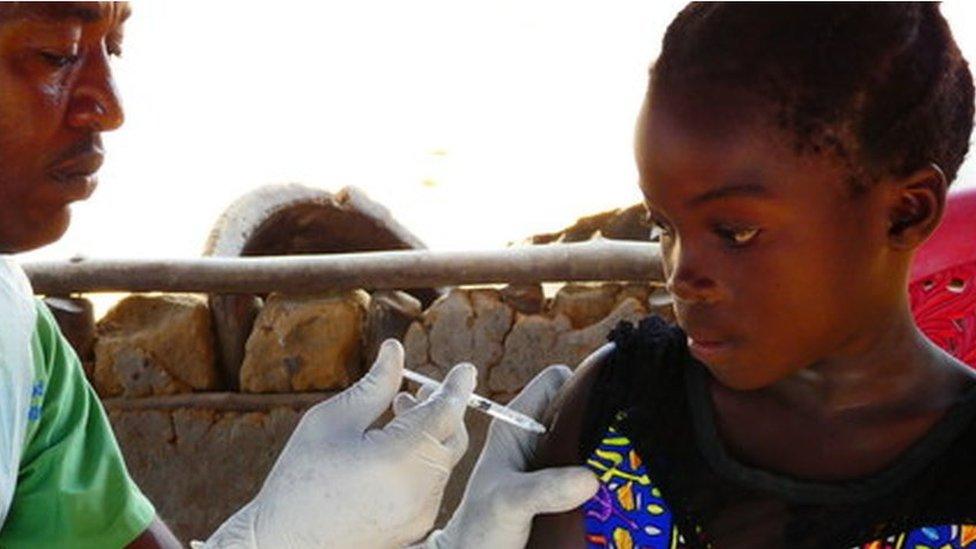 Ugandan girl being given HPV vaccine funded by UK aid.