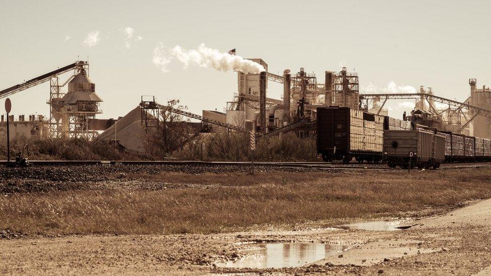 Industrial revolution mining factory on railroad tracks - stock photo