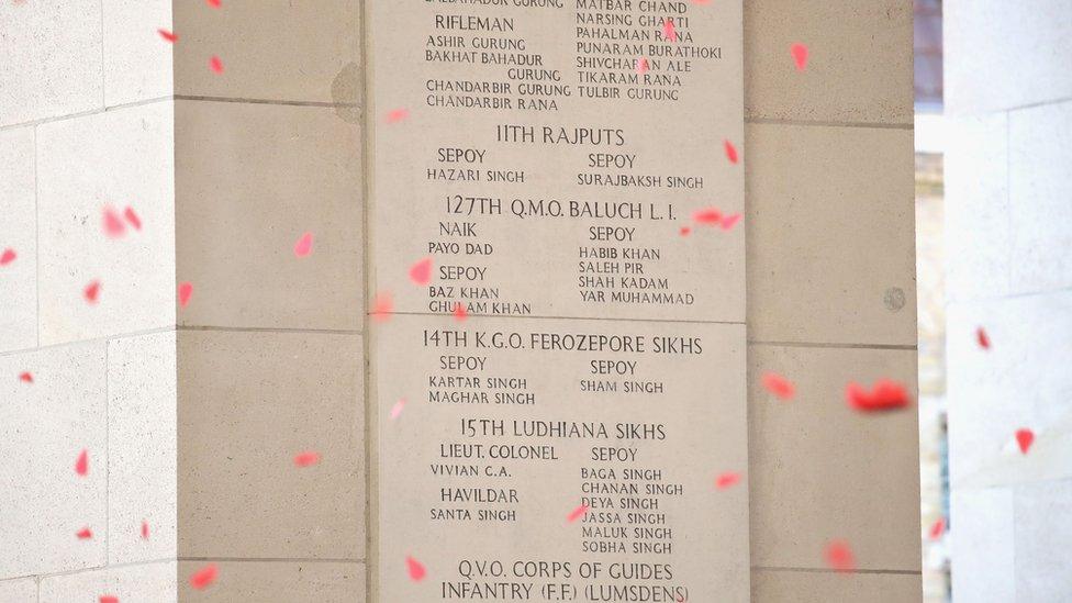 Paper poppies fell to represent the soldiers named on Menin Gate