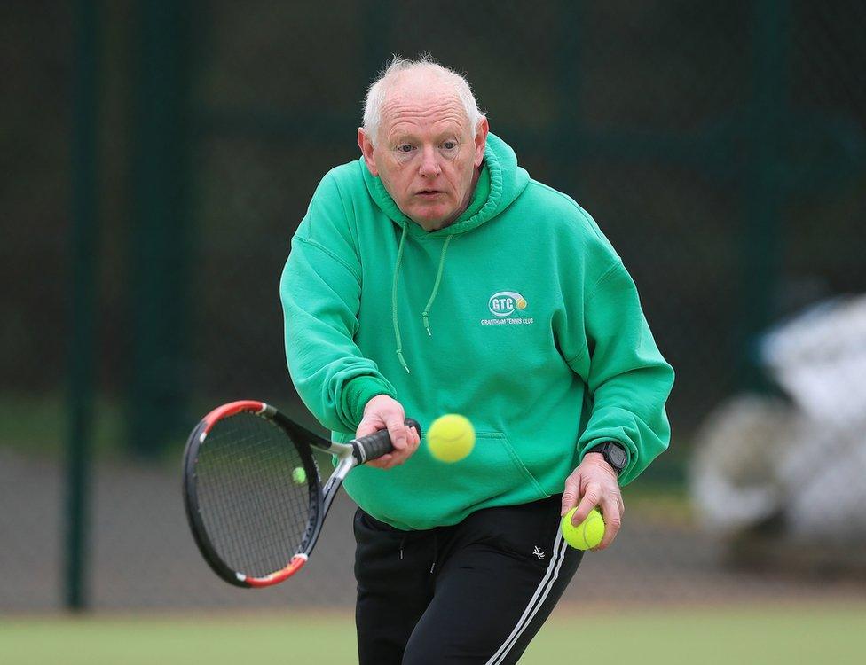 A tennis player hits a ball on a court