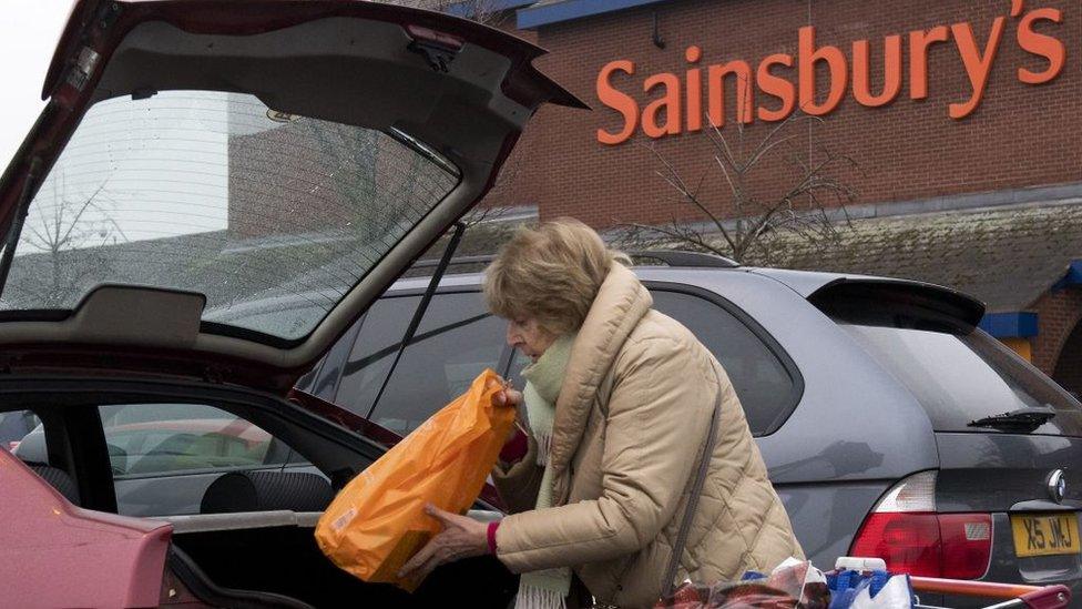 Woman loading car in Sainsbury's car park