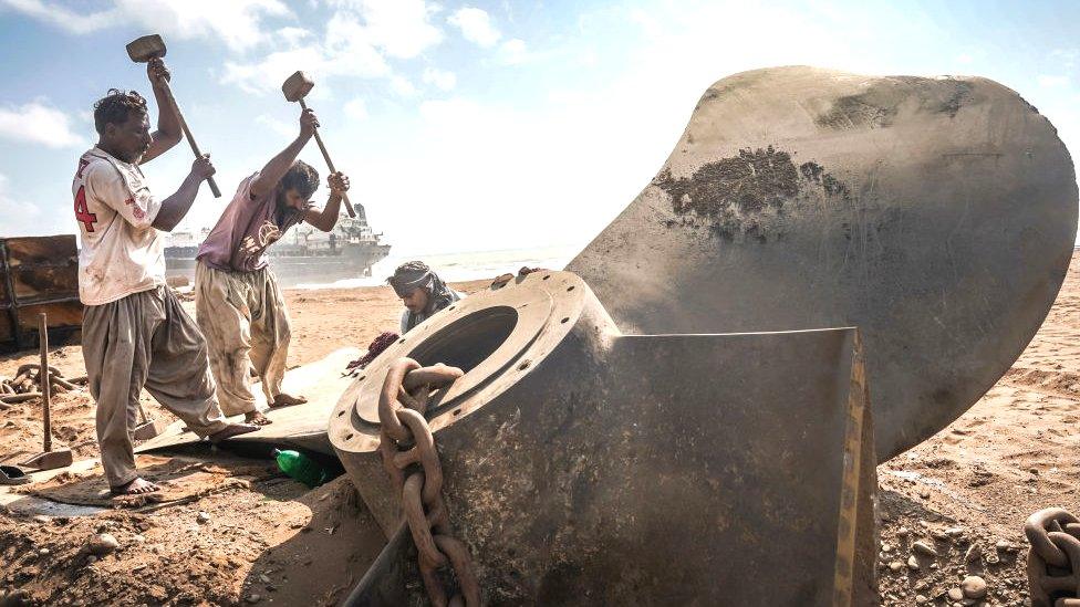 Labourers work on breaking down a decommissioned ship on September 20, 2021 in Gadani, Pakistan