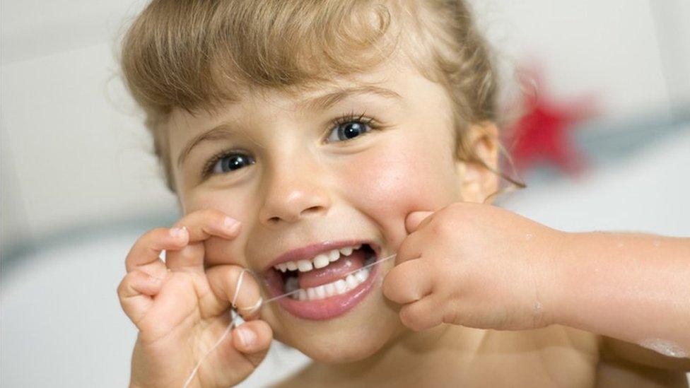 girl flossing her teeth