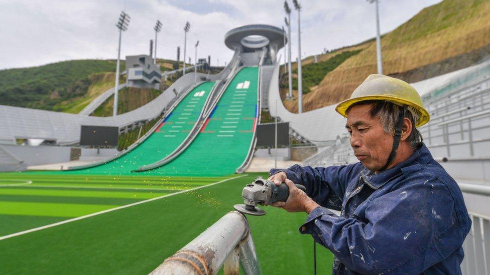 A worker polishes railing at the national ski jumping center which is under construction in Chongli district for the Beijing 2022 Winter Olympics on July 28, 2021 in Zhangjiakou, Hebei Province of China