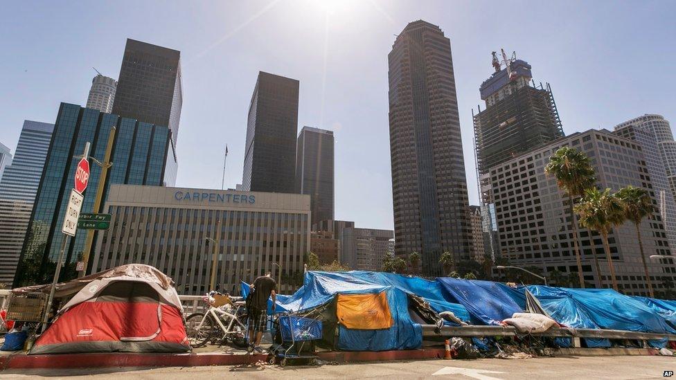 Tents used by the homeless line a downtown Los Angeles street with the skyline behind Tuesday, on 22 September 2015