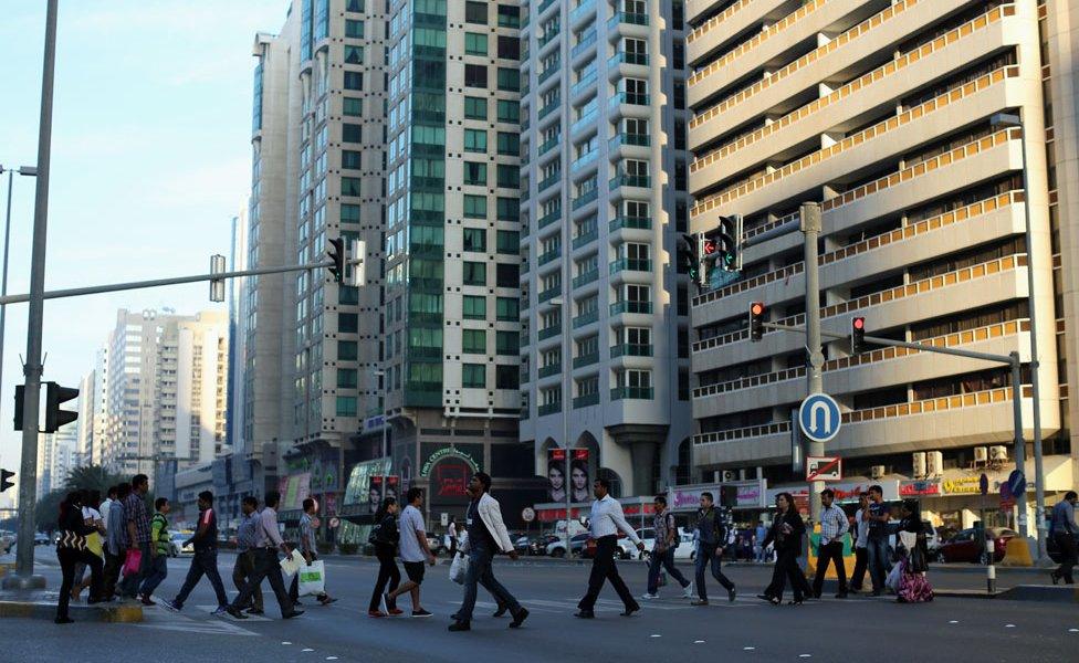 People walk across a main road in 2015 in Abu Dhabi, United Arab Emirates