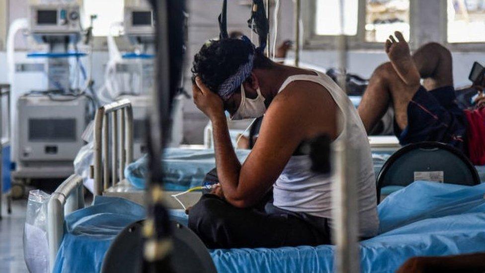 A patient who has Covid-19 sits on his bed in an ICU ward at the government-run St. George hospital on May 27, 2021 in Mumbai, India