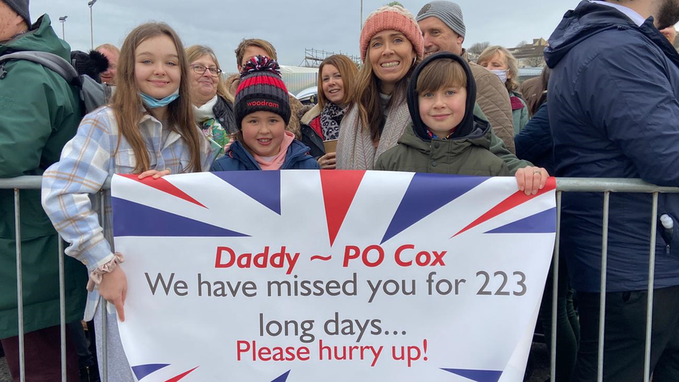 The Cox family holding a banner