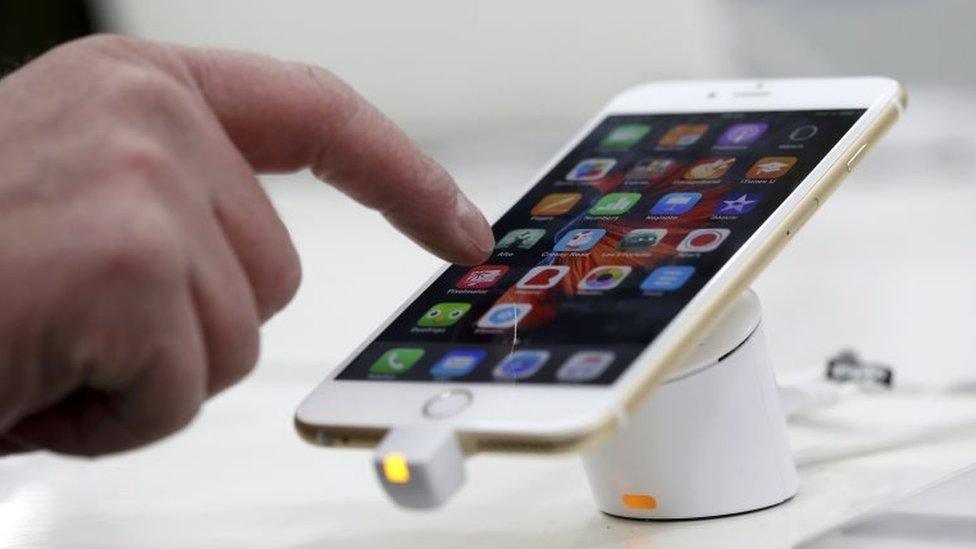 A man tests a mobile phone, an iPhone 6 by Apple in a shop in Munich, Germany, 27 January 2016.