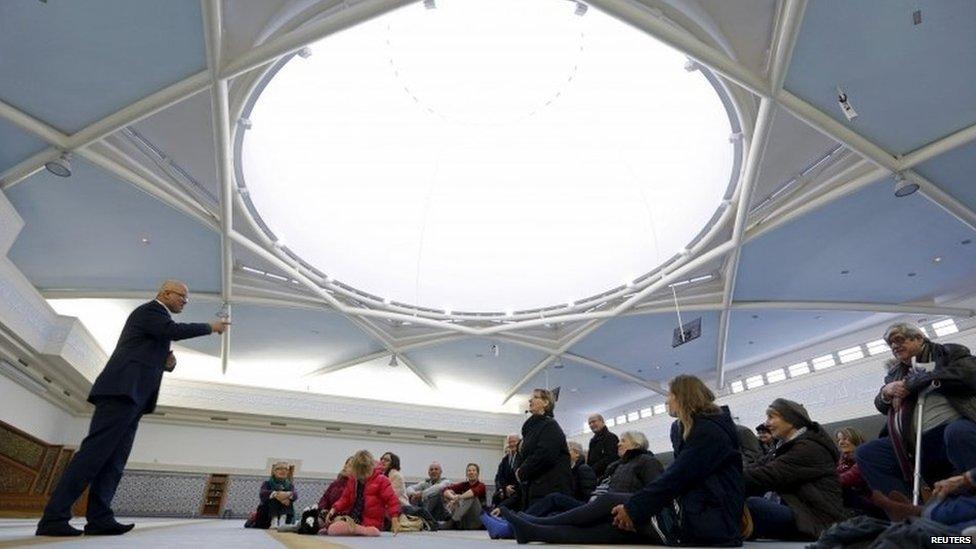 People listen to the explanations of guide Mohamed Latahi (L), as they visit the Strasbourg Grand Mosque during an open day weekend for mosques in France