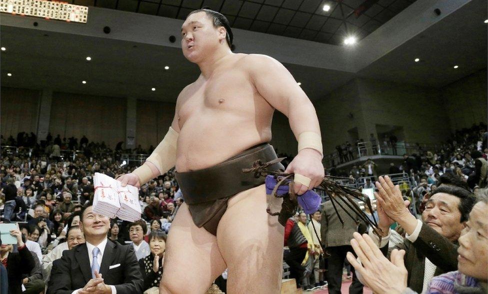 Fans applaud yokozuna-ranked sumo wrestler Hakuho at a tournament on November 25, 2017.