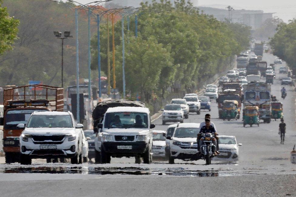 Traffic moves on a road in a heat haze during hot weather on the outskirts of Ahmedabad, India, May 12, 2022