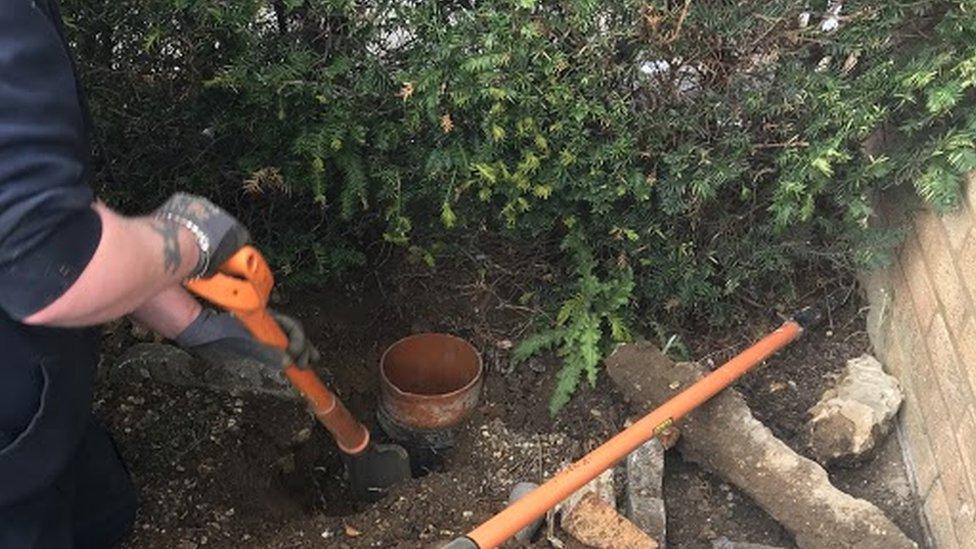 An engineer digging out pipes and concrete to get to the hedgehogs