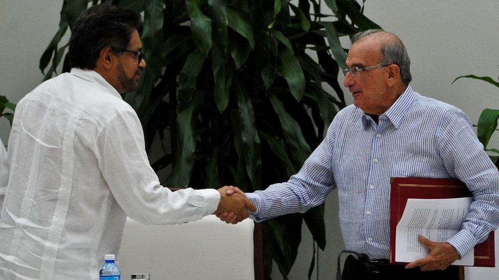 Guerrilla commander Ivan Marquez (left) and the head of the Colombian delegation for peace talks Humberto de la Calle (right) shake hands after signing a new peace agreement in Havana, 12 November 2016