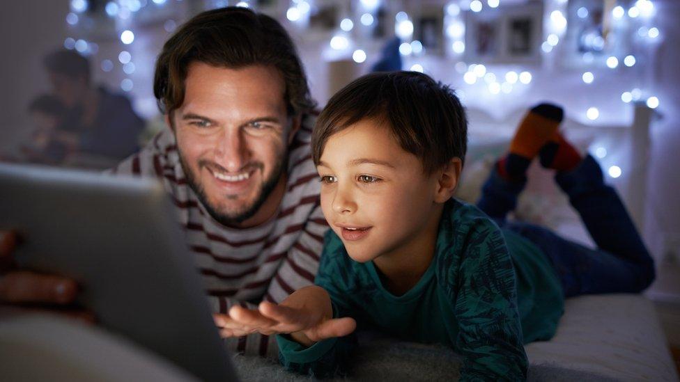 Father reading an iPad story to his son